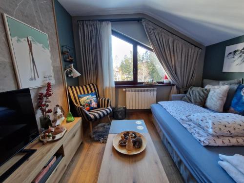 a bedroom with a bed and a living room at PinePino Borovets, aparthotel Borovets Gardens A60 in Borovets
