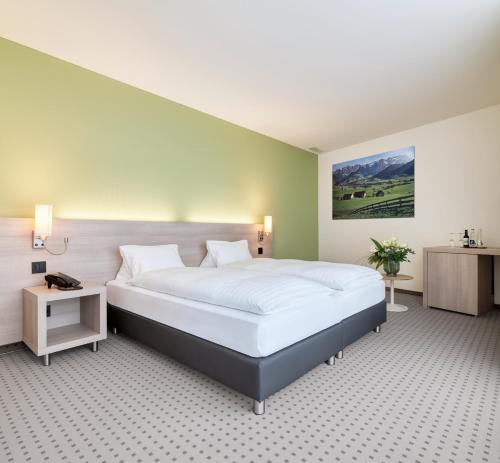 a bedroom with a large bed and a green wall at Hotel Eastside (free parking garage) in St. Gallen