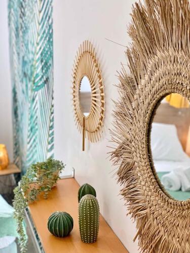 une table avec un cactus et des miroirs sur un mur dans l'établissement La croisée des chemins, à Montauban