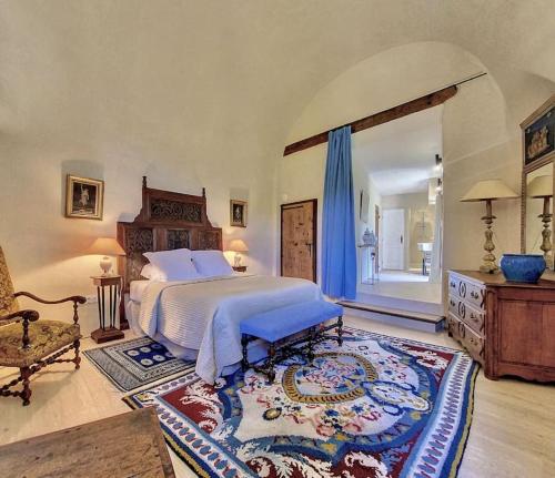 une chambre avec un grand lit et un tapis dans l'établissement Château de Sainte Jalle, à Sainte-Jalle