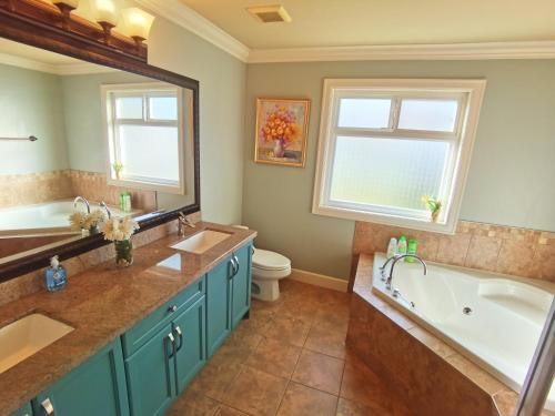 a bathroom with two sinks and a tub and a window at Luxurious house in willoughby center in Langley