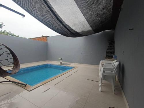 a swimming pool with two chairs and a table and a swimming pool at House 91 in Montes Claros