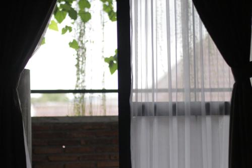 una ventana con una cortina blanca en nava one en Candi