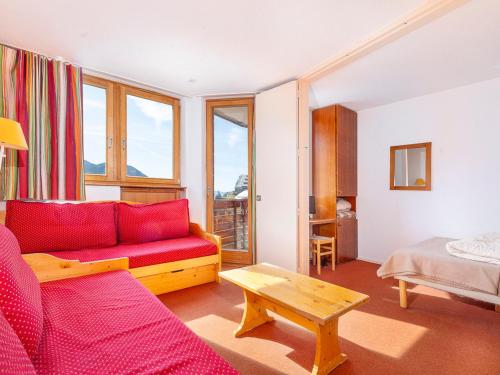 ein Wohnzimmer mit einem roten Sofa und einem Tisch in der Unterkunft Appartement Avoriaz, 2 pièces, 5 personnes - FR-1-314-260 in Morzine