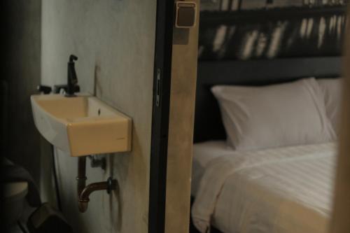 ein Badezimmer mit einem Waschbecken neben einem Bett in der Unterkunft nava one in Candi