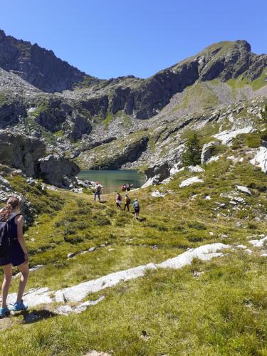 a group of people walking on a hill near a lake at Issime - da Carla (CIR n. 0001) in Issime