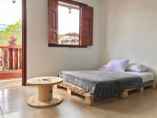 a bed in a room with a table and a window at Nature Hostel Salento in Salento
