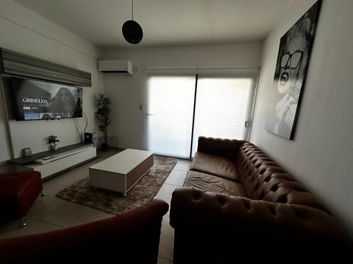 sala de estar con sofá y TV en Center Suites, 3 ambientes con cochera opcional en La Plata