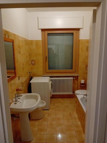 CampodennoにあるCasa vacanze Monicaのバスルーム(洗面台、トイレ、バスタブ付)