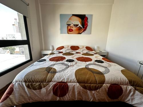 un dormitorio con una cama con una mujer con gafas de sol en Center Suites, 3 ambientes con cochera opcional en La Plata