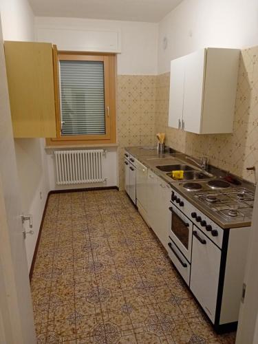 a kitchen with white cabinets and a stove top oven at Casa vacanze Monica in Campodenno