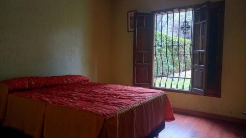 um quarto com uma cama e uma janela aberta em Casa Quinta en Maipú em Maipú