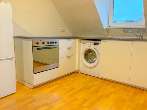 uma cozinha com um fogão e uma máquina de lavar roupa em Apartment über Neu Ulm's Dächern, 2 Schlafzimmer inkl. Stellplatz em Neu-Ulm