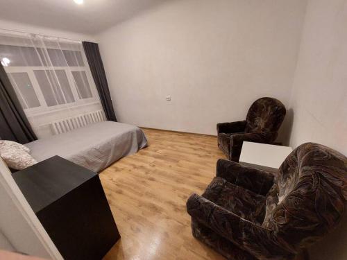 a living room with a bed and a couch and chairs at Comfy apartment with 2 bedrooms in Rīga