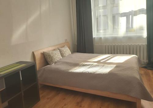 a bed sitting in a room with a window at Comfy apartment with 2 bedrooms in Rīga