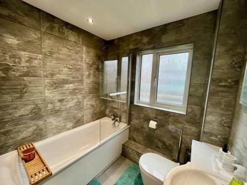 ein Badezimmer mit einer Badewanne, einem WC und einem Waschbecken in der Unterkunft Stylish Two Bedroom Flat Colindale, NW9 close to station in Colindale