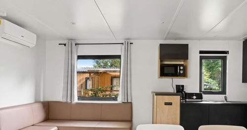 une pièce blanche avec une cuisine et une fenêtre dans l'établissement Mobil-home Premium Mayotte - 3 Ch - 2 sdb, à Biscarrosse