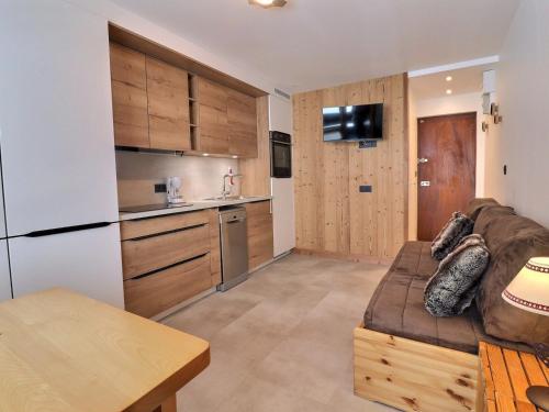 ein Wohnzimmer mit einem Sofa und einer Küche in der Unterkunft Studio Méribel, 1 pièce, 2 personnes - FR-1-182-167 in Méribel