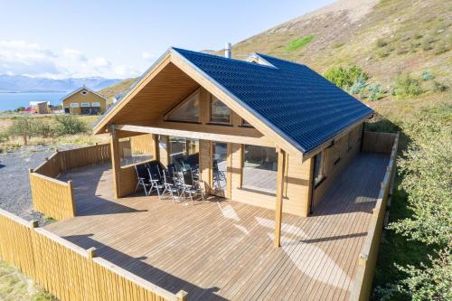 une maison avec un toit bleu sur une terrasse en bois dans l'établissement Beautiful cabin near Grenivík, à Grenivík