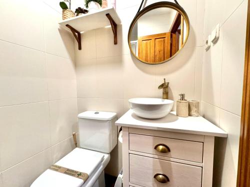 ein Badezimmer mit einem WC, einem Waschbecken und einem Spiegel in der Unterkunft Suite Imperial II * Historic Center * Early Check-in in Toledo