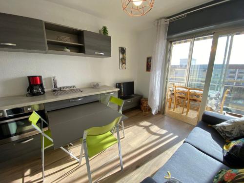 Il comprend un salon doté d'une cuisine avec un canapé et une table. dans l'établissement Appartement Cosy Proche Étang de Thau et Thermes - SE - 2 Pers - Animaux Acceptés - WiFi - FR-1-503-89, à Balaruc-les-Bains
