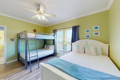 1 dormitorio con 2 literas y ventilador de techo en Smiles in Isla Del Sol en Galveston