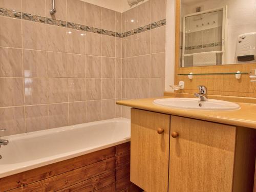 une salle de bain avec un lavabo et une baignoire dans l'établissement Appartement chaleureux 37m² au pied des pistes avec wifi et parking - FR-1-505-20, à Flumet