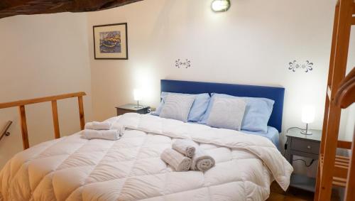 a bedroom with a large white bed with towels on it at Saint Mary House in Alghero