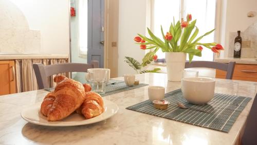 a table with a plate of croissants on it at Saint Mary House in Alghero