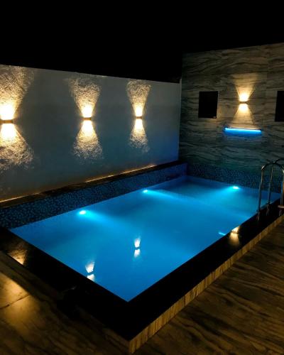 達曼的住宿－Juli villa，游泳池在晚上点亮,灯光照亮