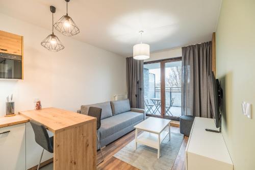 a living room with a couch and a table at Kraków Business Suite - City View with Balcony & Parking by Rentujemy in Krakow