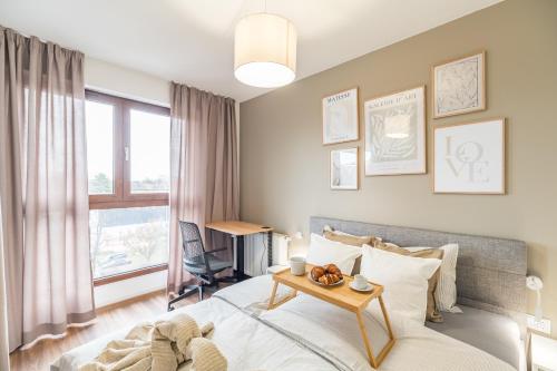 a bedroom with a bed and a table at Kraków Business Suite - City View with Balcony & Parking by Rentujemy in Krakow