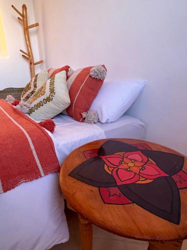 Schlafzimmer mit einem Bett und einem Holztisch in der Unterkunft kosasurfmorocco in Aourir