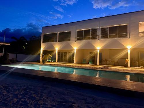 a villa with a swimming pool at night at Pension Irivai appartement PUATOU 1 chambre bord de mer in Uturoa