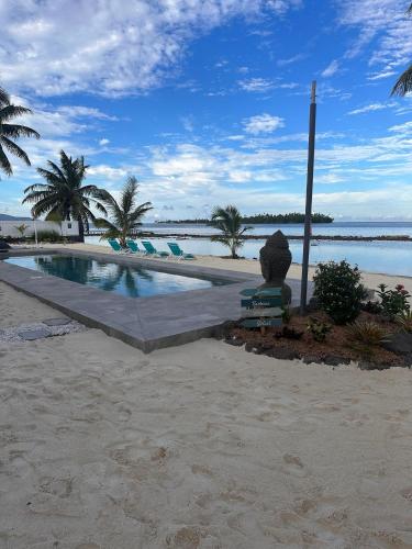 a swimming pool on the beach next to the ocean at Pension Irivai appartement PUATOU 1 chambre bord de mer in Uturoa