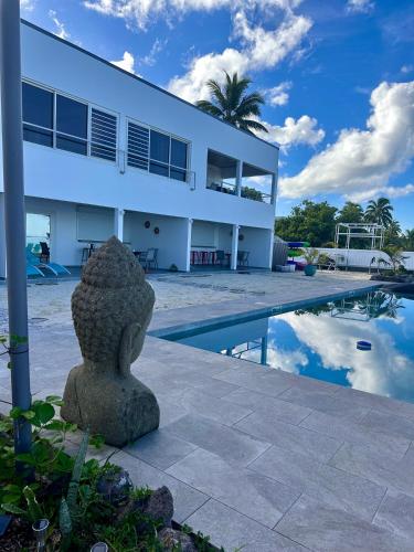 a villa with a swimming pool and a building at Pension Irivai appartement PUATOU 1 chambre bord de mer in Uturoa