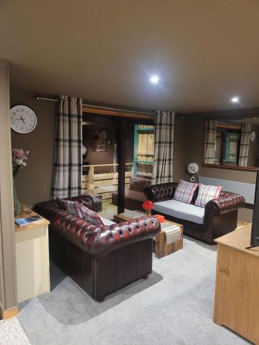 ein Wohnzimmer mit Ledermöbeln und einem Sofa in der Unterkunft THE MOORINGS in Broadford