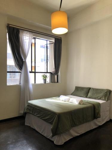 a bedroom with a large bed with a window at Sun's spacious apartment in Johannesburg