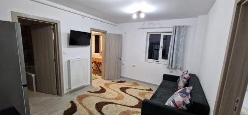 un salon avec un canapé et une télévision dans l'établissement Apartament 3 cam Grand Arena, à Bucarest