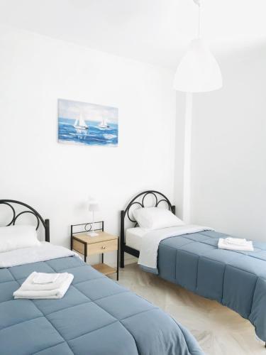 a bedroom with two beds and a sailboat in the water at Central Family Apartment in Preveza
