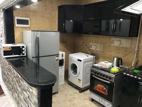 eine Küche mit einem Kühlschrank, einer Waschmaschine und einem Trockner in der Unterkunft Elite Sea view in Alexandria