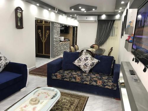 ein Wohnzimmer mit einem blauen Sofa und einem Tisch in der Unterkunft Elite Sea view in Alexandria