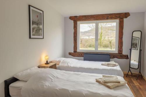 2 camas en una habitación con ventana en Le Garage, en Lorp Sentaraille