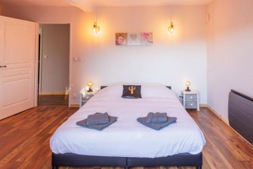 a bedroom with a large white bed with two towels on it at Le Garage in Lorp Sentaraille
