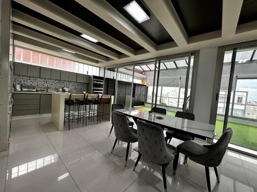 cocina grande con mesa, sillas y ventanas en Center Suites Apartamento super fantastico POR MES!! en La Plata