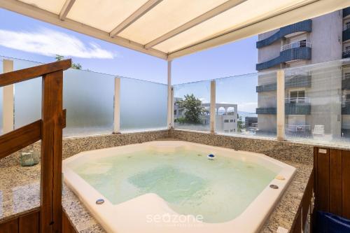 una vasca idromassaggio sul balcone di un edificio di Lindo apto confortável e bem localizado MOS104 a Florianópolis