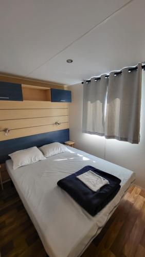 a large white bed with a black blanket on it at Anne Marie Touzani in Boofzheim