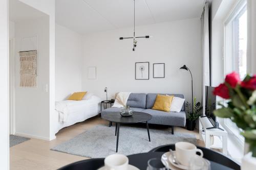 un soggiorno con divano e tavolo di Great location, quiet and new with balcony&cafe a Tampere