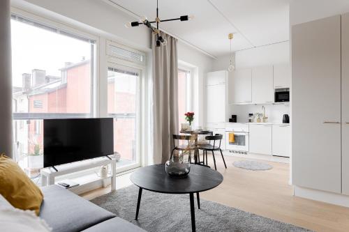 uma sala de estar com um sofá e uma mesa em Great location, quiet and new with balcony&cafe em Tampere