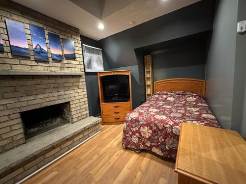 1 dormitorio con 1 cama, chimenea y TV en Nox Hostel en Toronto